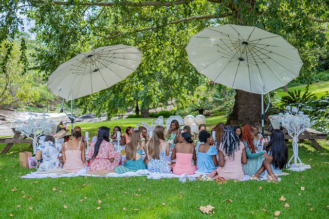 Group celebration photographed beneath garden parasols