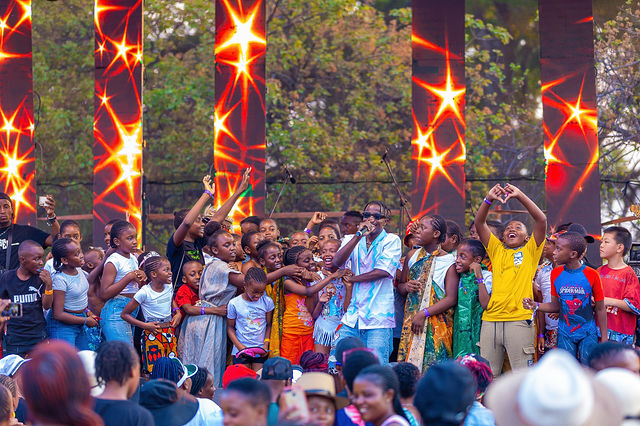 Audience gathered around a colourful live stage