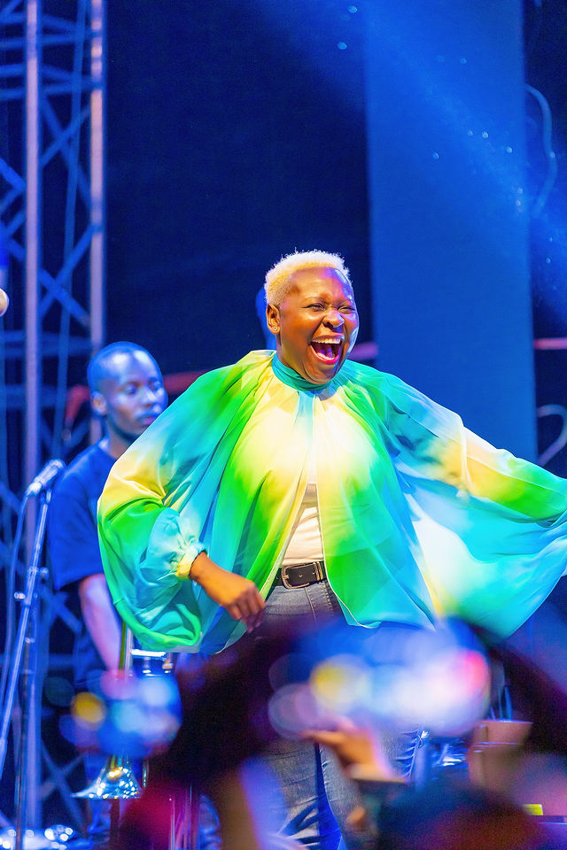 Performer singing under blue stage lights